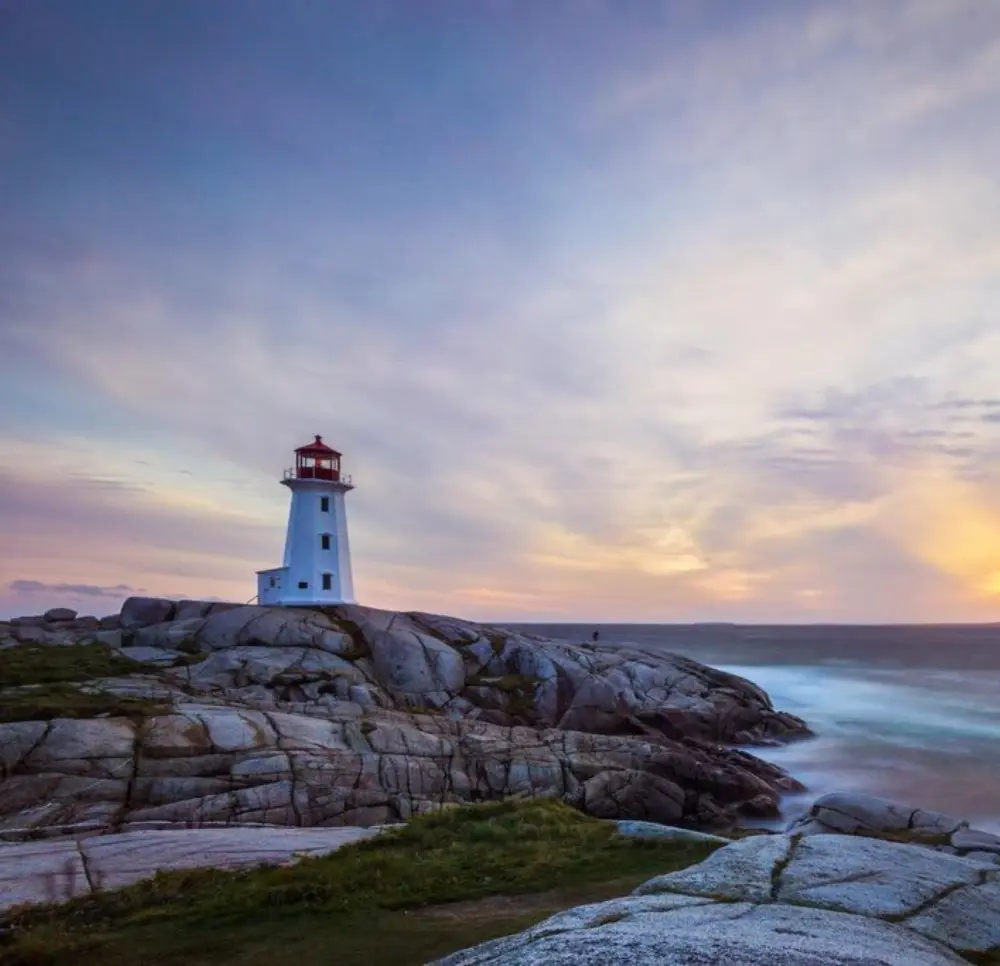 Lighthouse on rocky Massachusetts coastline at sunset – symbolic of guidance and protection, representing Graydon Sommer PLLC, Massachusetts Civil Litigation Attorneys